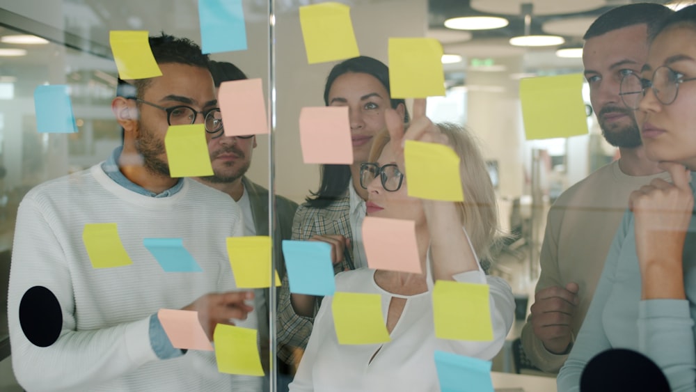 Team synthesizing insights on a glass wall